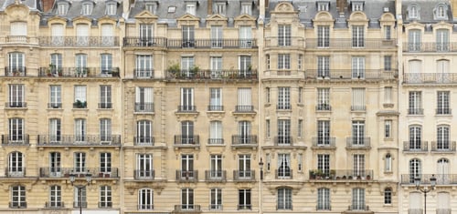 Découvrez ces élégants immeubles haussmanniens parisiens, caractéristiques des quartiers résidentiels de la capitale française. Cette photo illustre parfaitement les logements anciens souvent concernés par les augmentations de loyer et les diagnostics de performance énergétique (DPE). Avec leurs façades en pierre de taille, balcons en fer forgé et fenêtres alignées, ces bâtiments sont typiques des biens immobiliers soumis aux nouvelles réglementations énergétiques. Apprenez dans notre article comment le DPE peut vous aider à contester une hausse de loyer abusive et protéger vos droits en tant que locataire face à des logements parfois mal isolés et énergivores. Idéal pour comprendre l'impact du DPE sur la gestion de votre location dans un immeuble ancien à Paris.