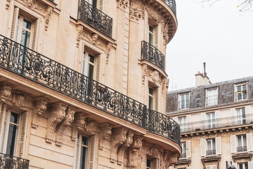 Découvrez un immeuble haussmannien typique de Paris, illustrant l’architecture résidentielle concernée par le nouveau décret relatif à l’expulsion locative. Cette photo met en avant les détails caractéristiques des façades parisiennes : balcons en fer forgé richement ouvragés, fenêtres hautes à persiennes, sculptures ornementales et corniches élégantes. Ces logements, souvent sujets à des régulations strictes en matière de location et d’expulsion, reflètent l’enjeu du décret visant à encadrer les procédures d’expulsion pour mieux protéger locataires et propriétaires. Une vue représentative des bâtiments où les nouvelles mesures légales sur les expulsions locatives trouvent une application concrète.
