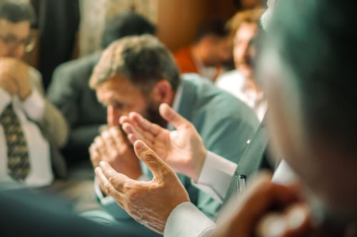 Un locataire et des copropriétaires participent à une assemblée générale en discutant et prenant des notes